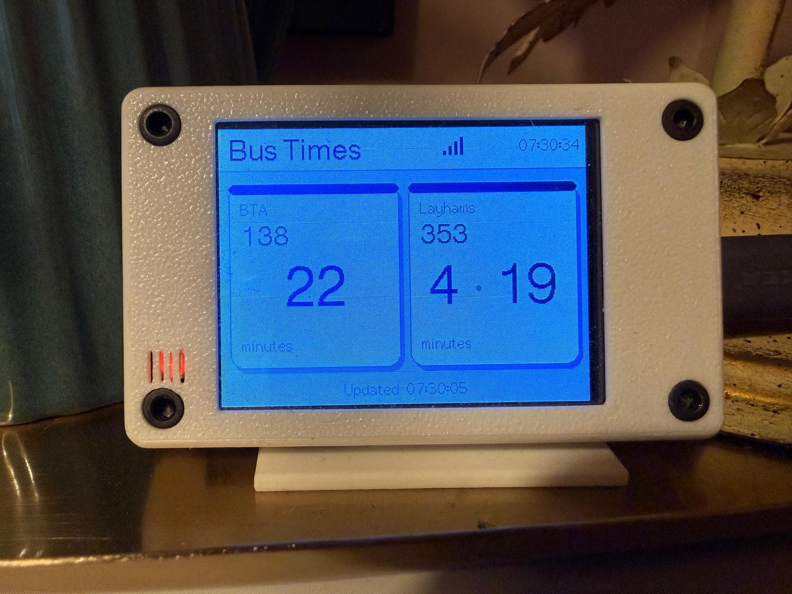 TheNextBus device on a table showing live bus arrival times